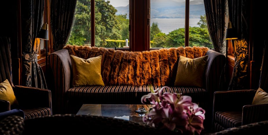 Duisdale House lounge with dark luxurious furnishings and leather sofa.