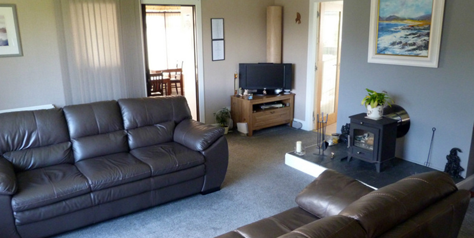 Ardmorn Lounge room with leather sofas and TV.