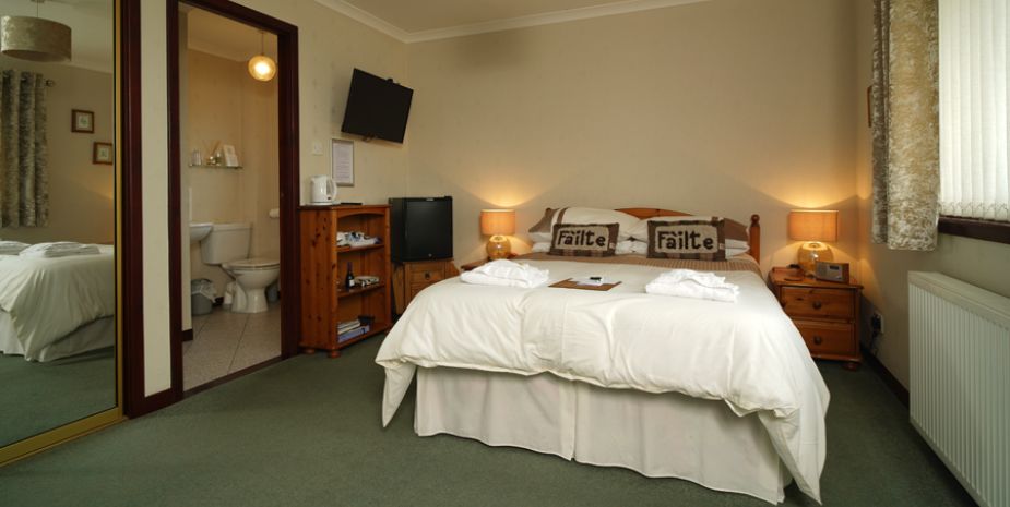 Borve Guesthouse Double Room with white linen and wooden furniture.