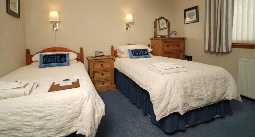 Borve Guesthouse Twin Room with white linen and wooden furniture.