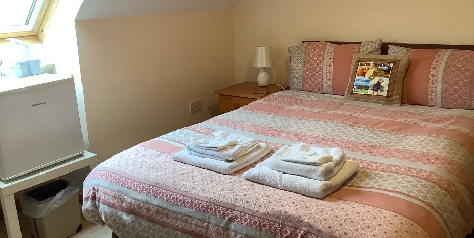 Rowan Tree in Uist, double bedroom with pink patterned bed linen and velux window.