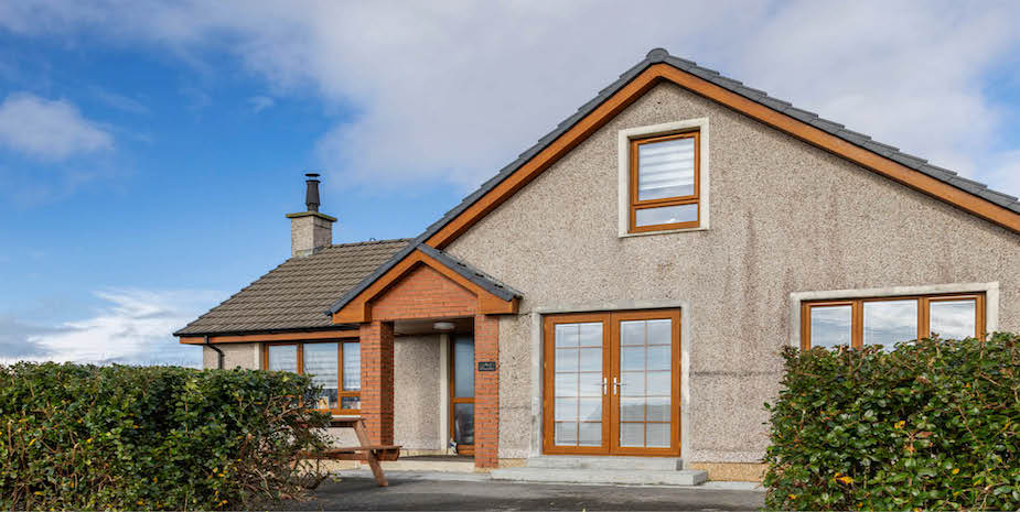 Ard Buidhe B&B exterior with a large driveway and spacious well kept front garden on the Isle of Barra.